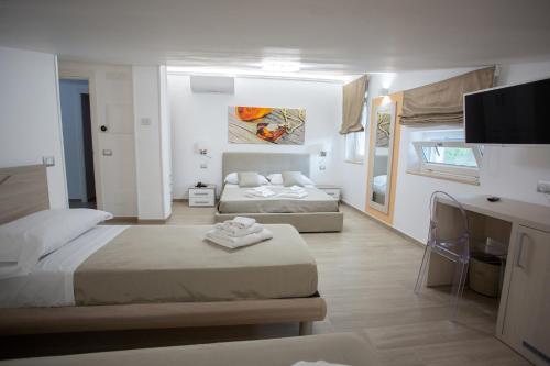 a hotel room with two beds and a television at Miramare Castellabate Resort in Santa Maria di Castellabate