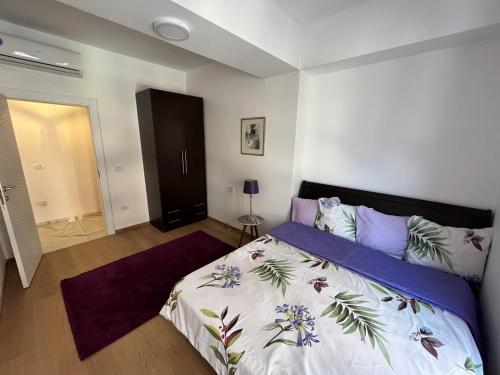 Schlafzimmer mit einem Bett mit einer blauen und weißen Bettdecke in der Unterkunft Apartment OLE in Struga