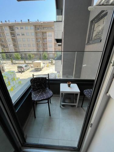 einen Balkon mit 2 Stühlen, einem Tisch und einem Fenster in der Unterkunft Apartment OLE in Struga