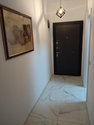 einen Flur mit einem Gemälde an der Wand und einer Tür in der Unterkunft Apartment OLE in Struga