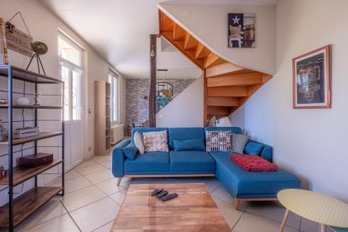 a living room with a blue couch and a staircase at Maison de la Gaîté in Amboise