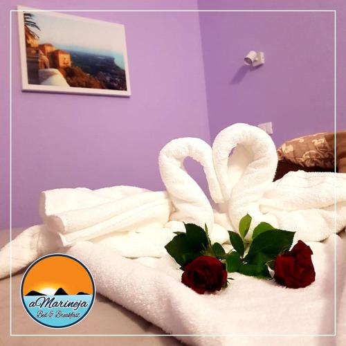 Dos cisnes hechos de toallas en una cama en B&B aMarineja en Nicotera Marina