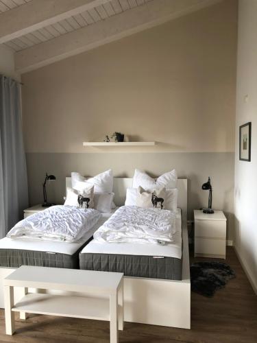 two beds in a bedroom with white walls at Ferienwohnung Mester in Osterrönfeld