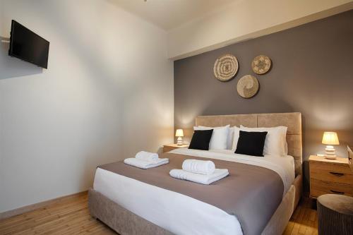 een slaapkamer met een groot bed met twee handdoeken bij Le Centre Ville in Athene
