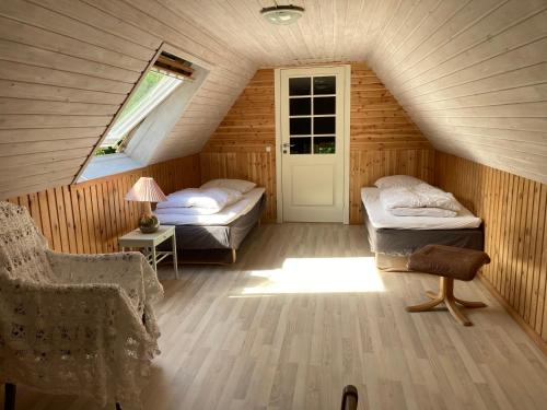 a attic room with two beds and a window at Mor’s hus Læsø in Læsø