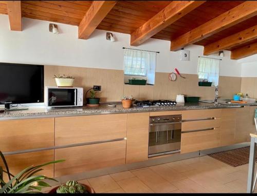 cocina con armarios de madera y horno con fogones en Casa Ester, en Preganziol