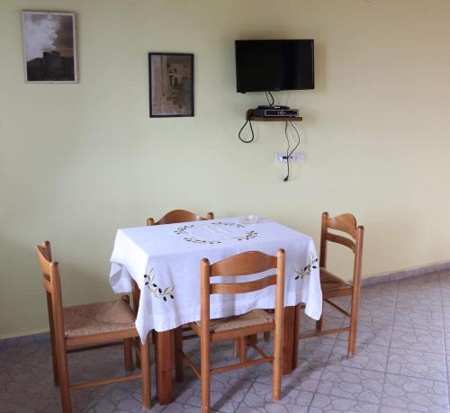 a table with chairs and a tv on the wall at Panorama Apartments in Marathokampos
