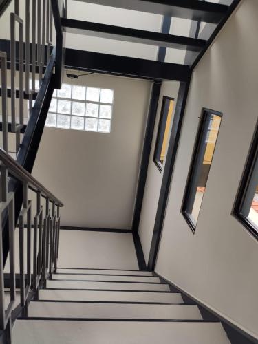a staircase in a house with black and white ceilings and windows at Departamento Sector de la Embajada Americana in Quito