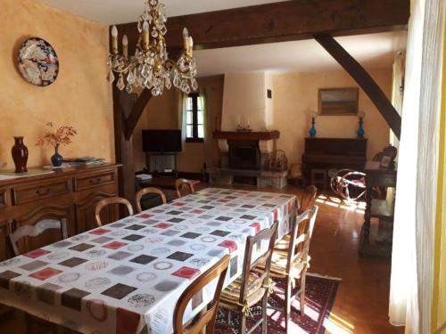 een eetkamer met een tafel en stoelen en een kroonluchter bij Maison de 5 chambres avec jardin amenage et wifi a Le Bugue in Le Bugue