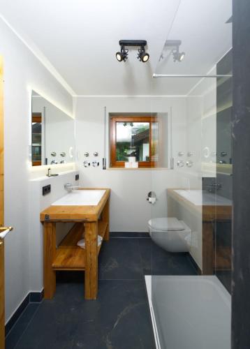 a bathroom with a sink and a tub and a toilet at Ferienwohnung Schloßblick in Füssen