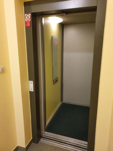 eine Tür, die in ein Zimmer mit einem grünen Flur führt in der Unterkunft Evergreen apartments hotel in Karlsbad