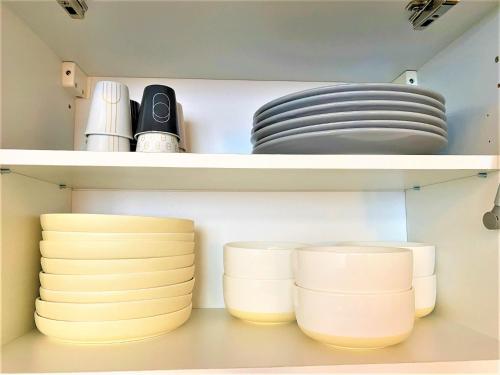 une étagère remplie de assiettes et de bols dans une cuisine dans l'établissement Appartements Rue Sarret XXL, à Angers