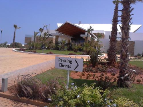 a sign in front of a building with a parking sign at Bahia Golf Beach Bouznika appart in Bouznika