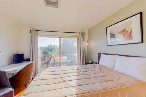 a bedroom with a large bed and a balcony at Cascade Canyon Home in Redmond
