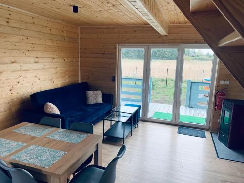 a living room with a blue couch and a table at Kamyczek in Stare Juchy