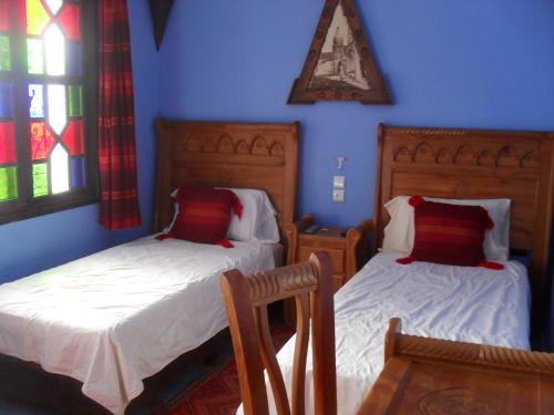 two beds in a room with blue walls at Dar Lbakal in Chefchaouene