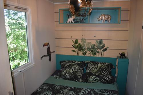 een kleine kamer met een bed en een raam bij mobil-home sur terrain bucolique in Hyères