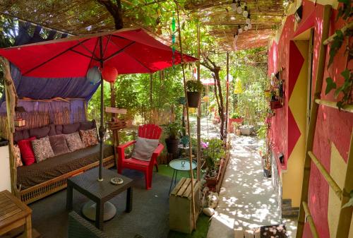 a living room with a couch and a red umbrella at La Bulle dans le Palmier in Toulouse