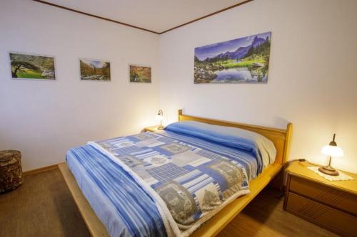 a bedroom with a bed and some pictures on the wall at Il Marangon in Prato Carnico