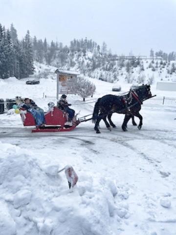 a horse drawn sleigh with people on it in the snow at Karczma Kubalonka in Istebna