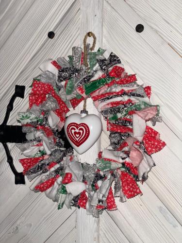 a christmas wreath with a heart on a wall at Karczma Kubalonka in Istebna