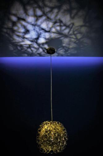 a pendant light with a tree in the background at DESIGN SUITES Boutique Hotel - Adults Only in Santa Maria