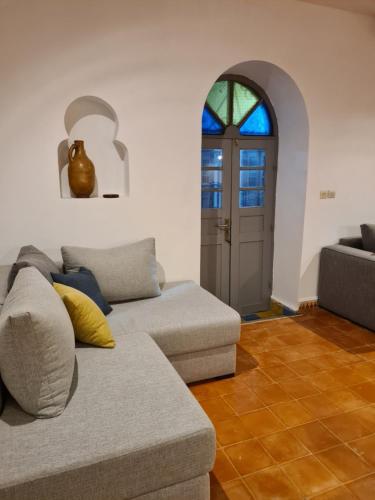 a living room with a couch and a door at Villa Al Kharoube in Essaouira