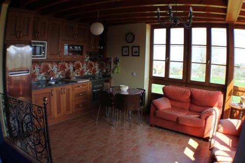 リャネスにあるChinijosII apartamento ruralrelax y tranquilidad entre el mar y la montañaの赤いソファとテーブル付きのキッチン