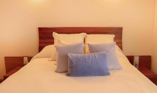 a bed with white pillows on top of it at Casa Paquita in Calpe