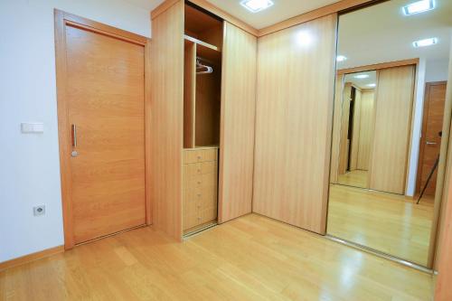 a walk in closet with wooden doors and a mirror at Casa Paquita in Calpe