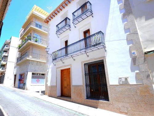 a white building with two balconies on a street at Casa Paquita in Calpe