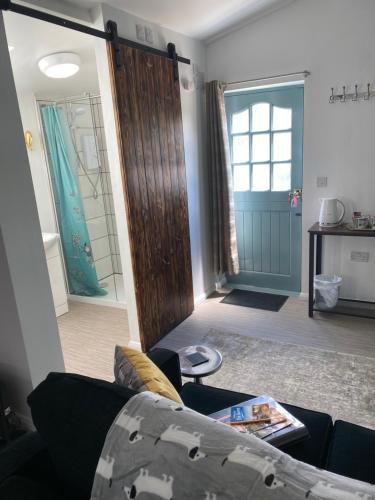 a living room with a couch and a sliding door at Self-contained, Framlingham Snug, Private Parking, no cooking facilities in Framlingham
