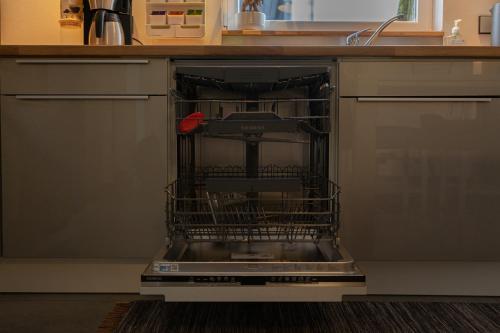 a dishwasher with its door open in a kitchen at Les Pantoufles dans le Pré in Eppeldorf