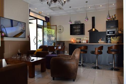 a restaurant with a bar with a couch and chairs at Hôtel Saint Albert in Sarlat-la-Canéda
