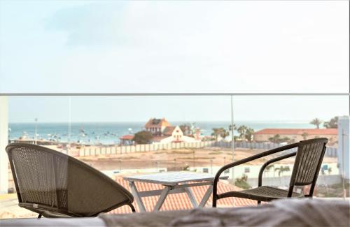 a table and chairs on a balcony with a view of the beach at DESIGN SUITES Boutique Hotel - Adults Only in Santa Maria