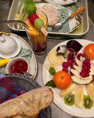 a table with plates of food and fruit on it at La Bulle dans le Palmier in Toulouse