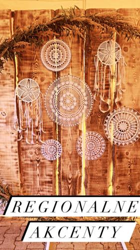 a wall with white chandeliers hanging from it at Karczma Kubalonka in Istebna
