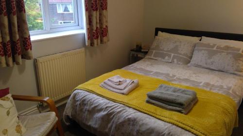 a bedroom with a bed with towels on it at Cosy house for business travel and pleasure in Bickershaw
