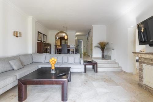 a living room with a couch and a table at OleHolidays Balcones de Bellavista in Estepona
