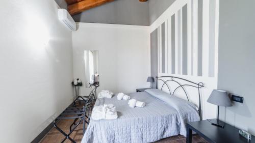 a white bedroom with a bed and a table at Casa Vecchio Mulino in Alba