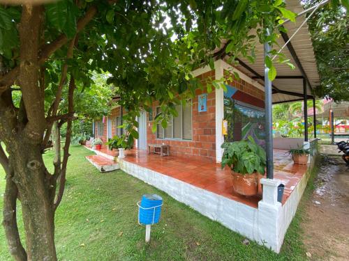 a house with a porch with potted plants on it at HOTEL CAMPESTRE VILLA BETEL in Rivera