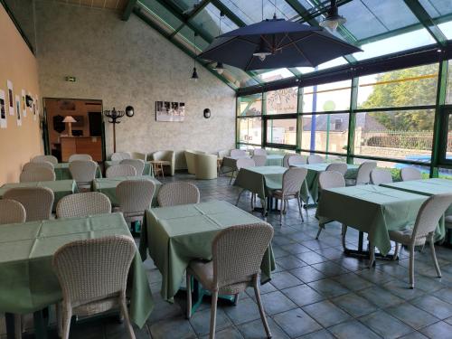 - une salle à manger avec des tables, des chaises et un parasol dans l'établissement L'AUBERGE DE L'OLIVE, à Dompierre-sur-Besbre