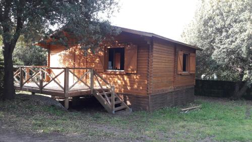 une petite cabane en bois avec un escalier dans une cour dans l'établissement chalets bois 150m de la plage, à Olmeto