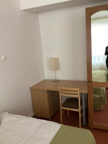 a bedroom with a desk and a bed and a mirror at Hotel-Restaurant Siesta Balea in Cumpăna