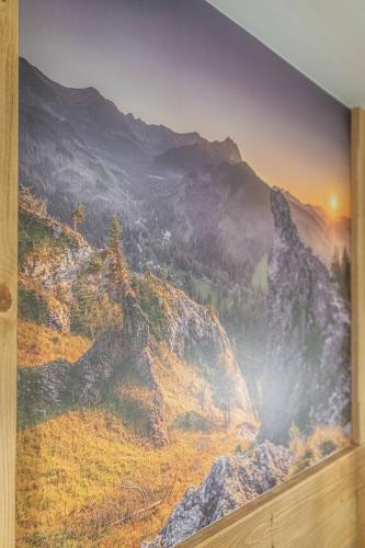 a painting on a wall with a mountain at Dworek nad Jałowcami z Jacuzzi in Biały Dunajec