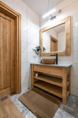 a bathroom with a sink and a mirror at Dworek nad Jałowcami z Jacuzzi in Biały Dunajec