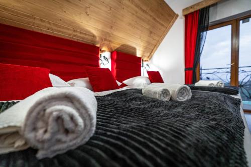 a bedroom with a large bed with towels on it at Dworek nad Jałowcami z Jacuzzi in Biały Dunajec