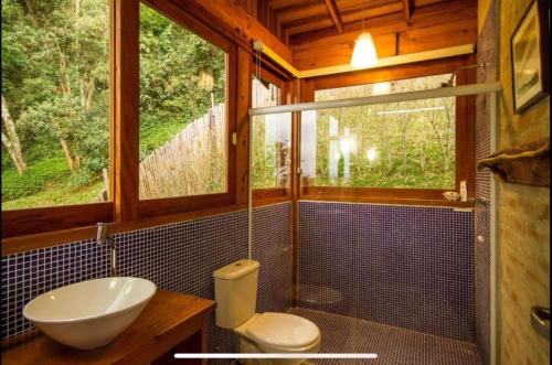 La salle de bains est pourvue d'un lavabo, de toilettes et d'une fenêtre. dans l'établissement Casa da Árvore - Mirante da Coruja - 10 km de Campos do Jordão, à Campos do Jordão