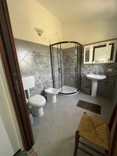 a bathroom with a shower and a toilet and a sink at Agriturismo Su Barraccu in Loceri
