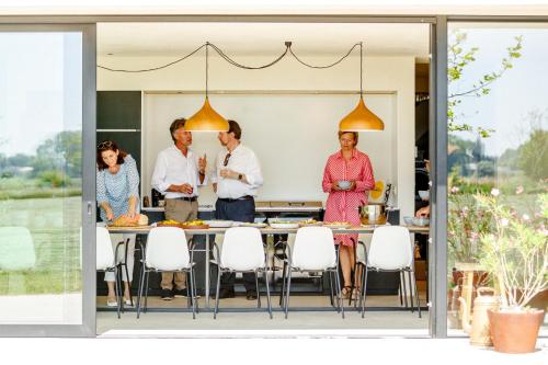a group of people standing around a table in a kitchen at Vakantiewoning Leie Lodge in Zulte